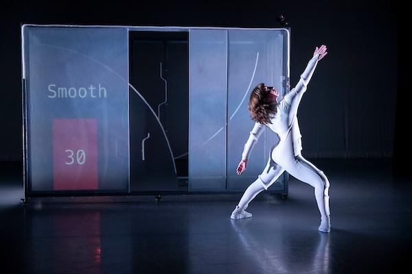 Dancer in white leotard in front of a screen that reads Smooth with a red bar and the number 30 in white text in it.